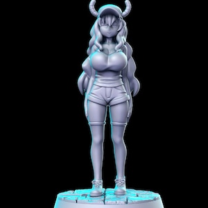 Puede incluir: Una figura impresa en 3D de color gris de un personaje femenino con cuernos, cabello largo y una gorra de béisbol. Lleva una camisa de manga corta y pantalones cortos. La figura está de pie sobre una base circular.