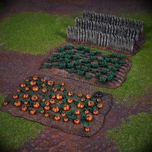 May include: A detailed miniature farm scene with three crop plots. The plots display models of pumpkins, leafy green plants, and tall stalks. The scene is set on a base of green and brown terrain, creating a realistic miniature landscape for tabletop gaming or display.