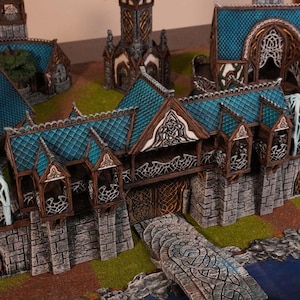 Puede incluir: Modelo de castillo de fantasía en miniatura con tejados de tejas de color verde azulado, muros de piedra y detalles de madera intrincados. El modelo incluye un puente, torres y tallas decorativas, sobre un paisaje verde.