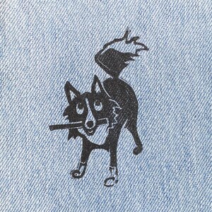 Peut inclure: Une illustration noire et blanche d'un chien avec la langue tirée, imprimée sur un patch en jean bleu.