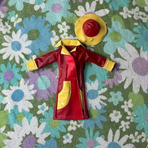 May include: A red and yellow raincoat with a yellow hat. The raincoat has a yellow pocket on the front. The hat has a red top and a yellow brim.