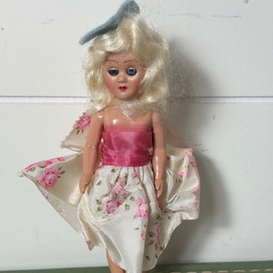 Vintage kitschy 1950s doll in pink and black dress