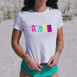 ベビーTシャツ ANGEL グラフィティ クロップトップ、レディース キュート レトロ シャツ サマー ビーチ、コケット、Y2k ベビーTシャツ、90年代 ベビーTシャツ 衣類、コンサート、バケーション