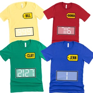 Puede incluir: Cuatro camisetas de diferentes colores con etiquetas de precio con nombres. Las camisetas tienen una pantalla digital con n&uacute;meros. Las camisetas son amarillas, rojas, verdes y azules.