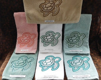 May include: Set of 10 embroidered towels featuring a sea turtle design in various colors, including white, blue, green, and brown. The towels are made of soft, absorbent cotton and are perfect for adding a touch of coastal charm to your bathroom.