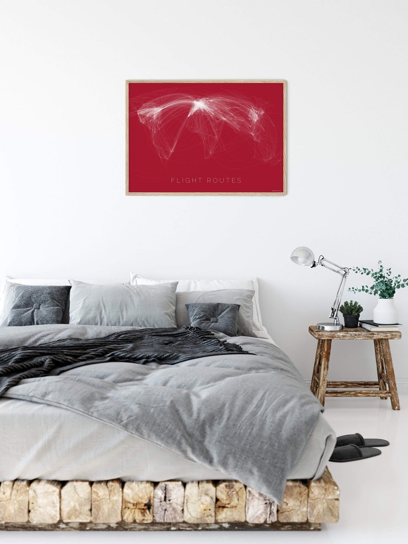 May include: A framed print of a world map with white lines representing flight routes on a red background. The text "FLIGHT ROUTES" is printed at the bottom of the map.