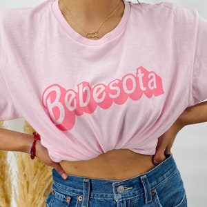 May include: A pink t-shirt with the text "Bebesota" in a pink bubble font.