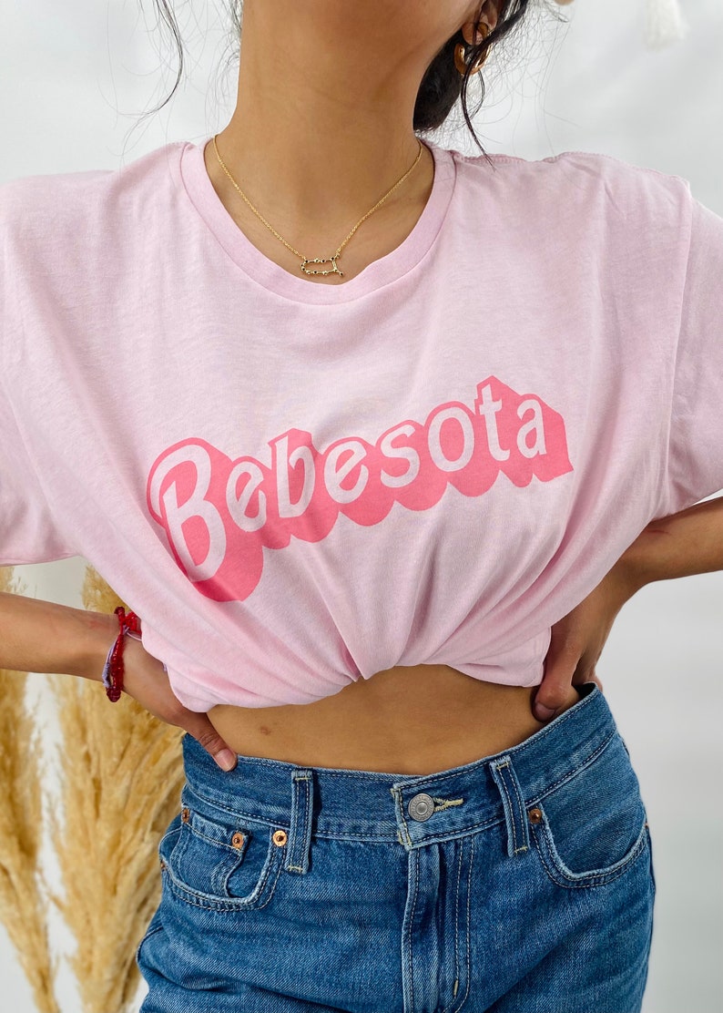 May include: A pink t-shirt with the text "Bebesota" in a pink bubble font.