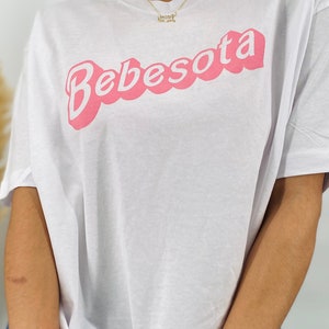 May include: White oversized t-shirt with a pink "Bebesota" graphic in a retro font.