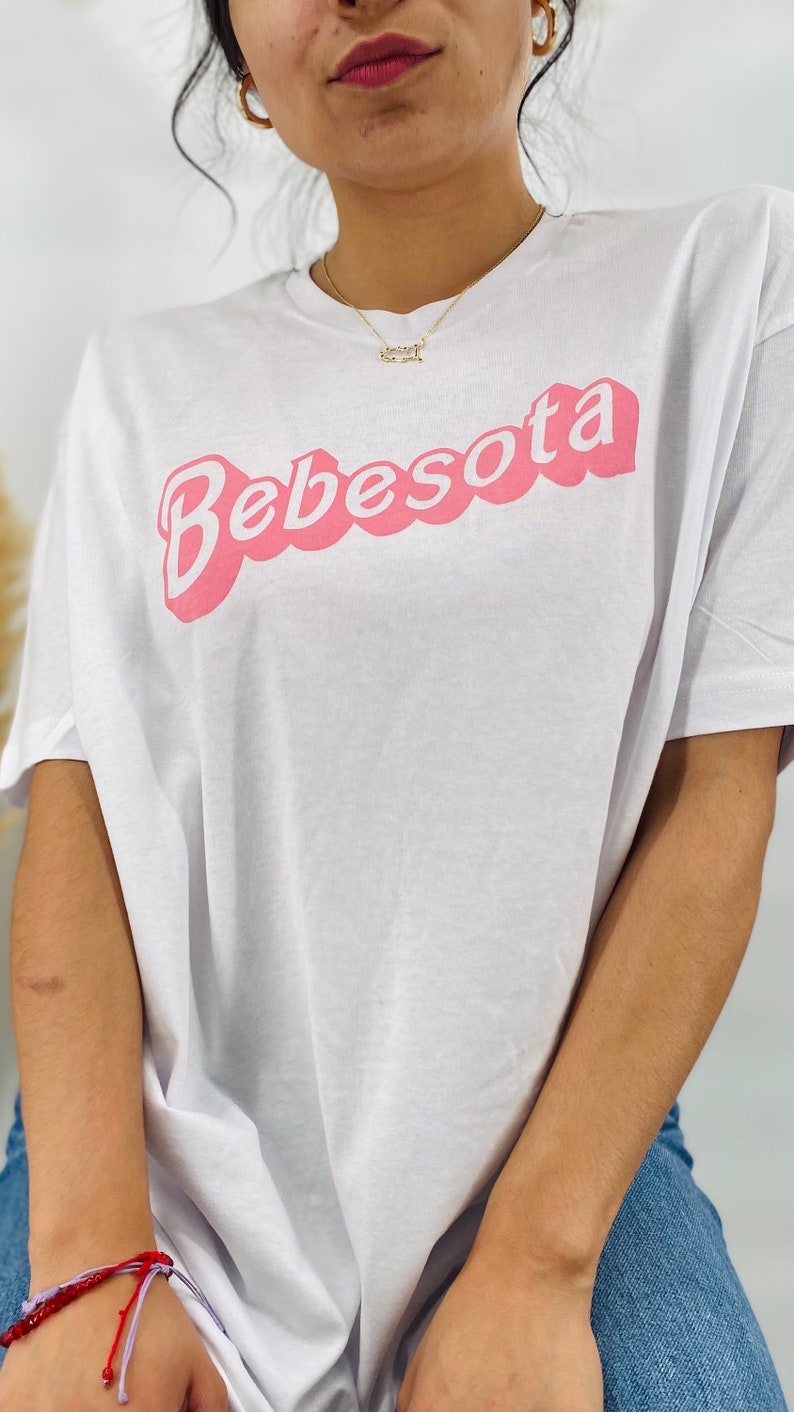 May include: White oversized t-shirt with a pink "Bebesota" graphic in a retro font.