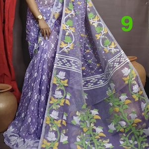 May include: A purple and white saree with a floral pattern. The saree has a pink border and is made of a sheer fabric.