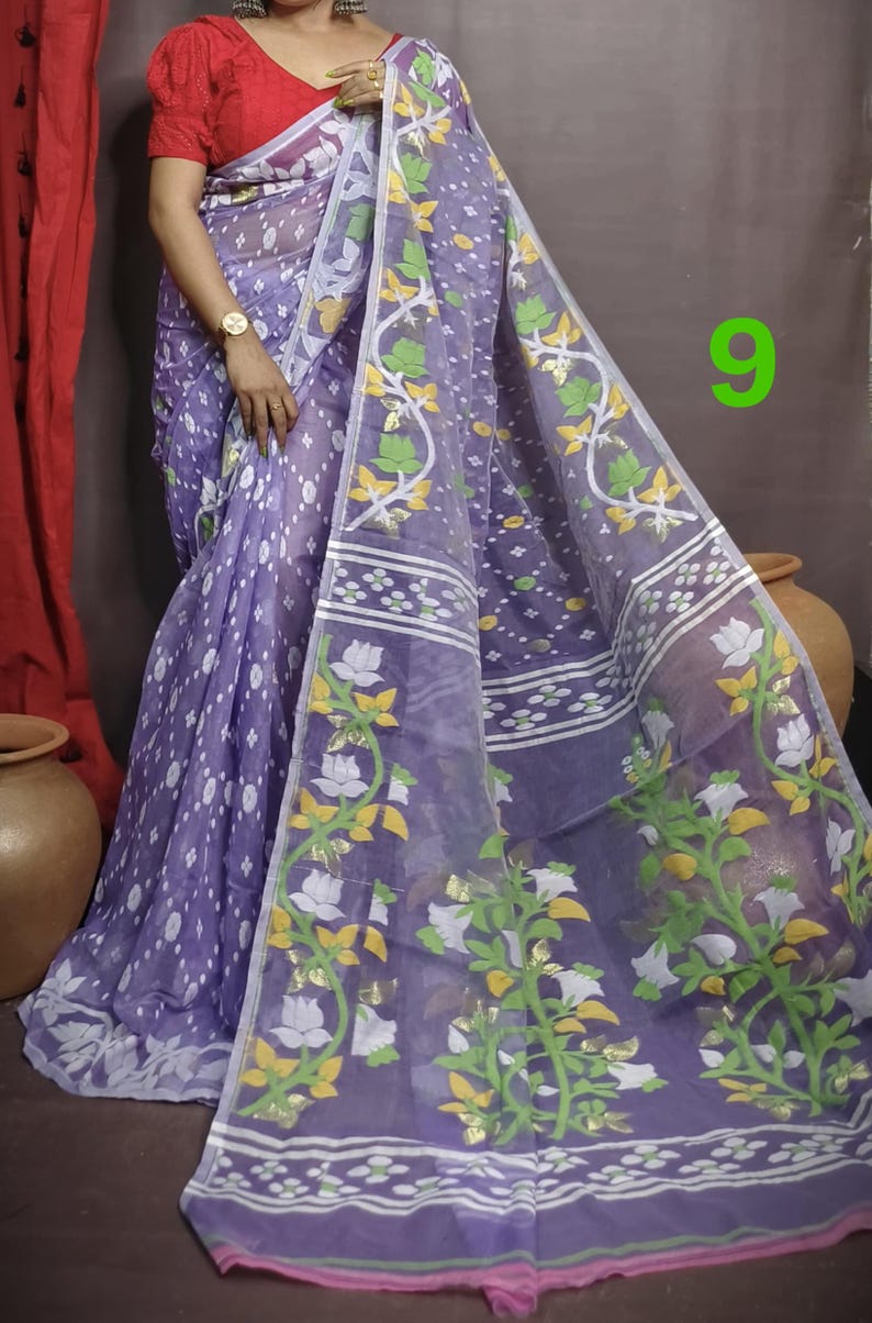 May include: A purple and white saree with a floral pattern. The saree has a pink border and is made of a sheer fabric.
