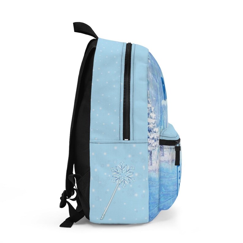 Puede incluir: Mochila azul claro con dise&ntilde;o de escena invernal. La mochila tiene cremallera, correas y asa negras. Un copo de nieve y una varita m&aacute;gica est&aacute;n en la parte delantera. El lateral tiene un paisaje invernal con &aacute;rboles cubiertos de nieve.