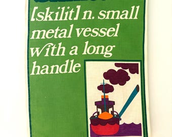 May include: A green linen tea towel with a colorful illustration of a boat with smoke coming from the chimney. The text "Skillet [skilit] n. small metal vessel with a long handle" is printed on the towel.  AIRM design by (David) POCKELL Pure linen Vat colours.