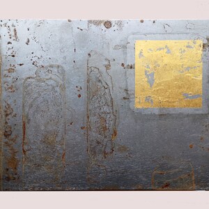 Könnte beinhalten: Eine silberne Metallplatte mit einem Quadrat aus Blattgold, das auf der Oberfläche angebracht ist. Die Platte hat eine strukturierte Oberfläche mit rostfarbenen Markierungen.