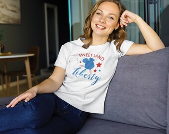 May include: White t-shirt with a blue and red graphic of a Mickey Mouse ice cream cone with the text "Sweet Land of Liberty".