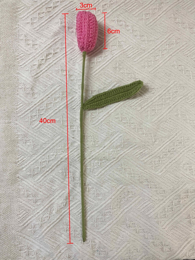 May include: A pink crocheted tulip flower with a green crocheted leaf. The stem is 40 cm long, the flower is 6 cm tall and 3 cm wide.
