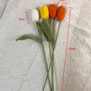 May include: A bouquet of four crocheted tulips in white, yellow, and orange. The tulips are 3 inches tall and the stems are 40 inches long.