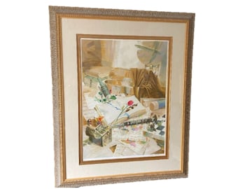 May include: A framed watercolor painting of a still life with a single red rose, books, and other objects on a table. The painting is in a gold frame with a white mat.