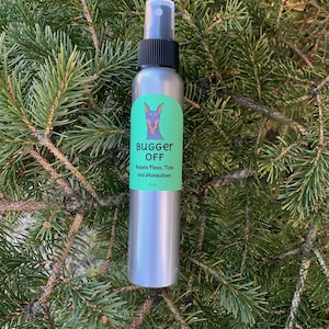 May include: A silver spray bottle with a black cap and a green label. The label features a dog illustration and the words "BUGGER OFF" and "Repels Fleas, Ticks and Mosquitoes". The bottle is 4 oz.