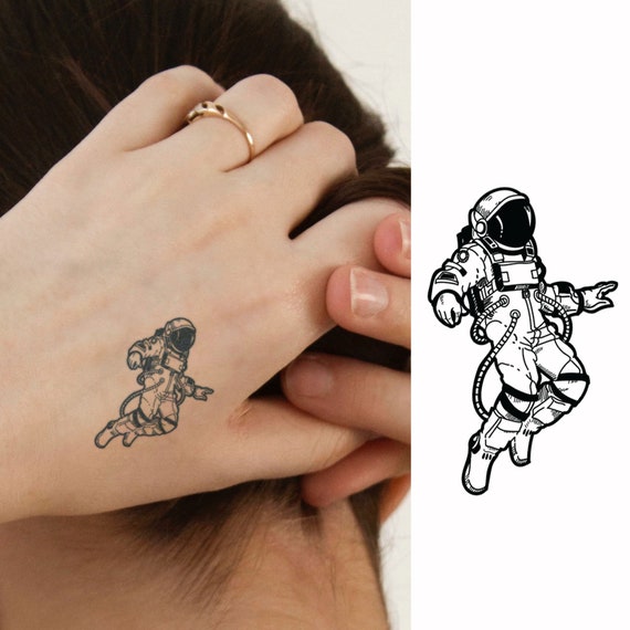 Astronaut tattoo on the left inner forearm