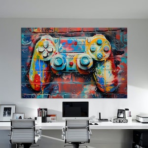 May include: A colorful abstract painting of a video game controller on a brick wall background. The controller is painted in shades of blue, yellow, red, and green. The background is a brick wall with graffiti.