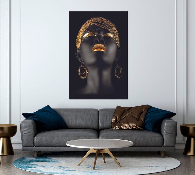 May include: A black and gold portrait of a woman with her eyes closed and gold jewelry. The woman's face is painted with gold makeup and she is wearing gold earrings.