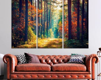 May include: A three-panel canvas print depicting a path through a forest with tall trees and colorful autumn leaves. The path is illuminated by sunlight streaming through the trees, creating a warm and inviting atmosphere.