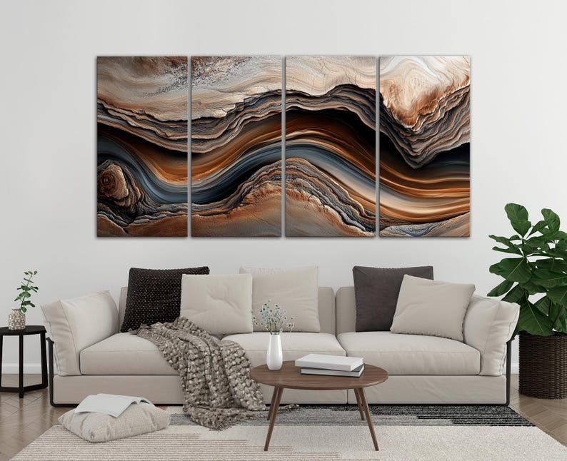 a modern living room with a large abstract painting hanging on the wall above a beige sofa. The painting has a swirling pattern of brown, orange, and gray colors, creating a dynamic and visually striking design. The room also includes a coffee table, a potted plant, and some decorative elements, contributing to the overall stylish and contemporary atmosphere.