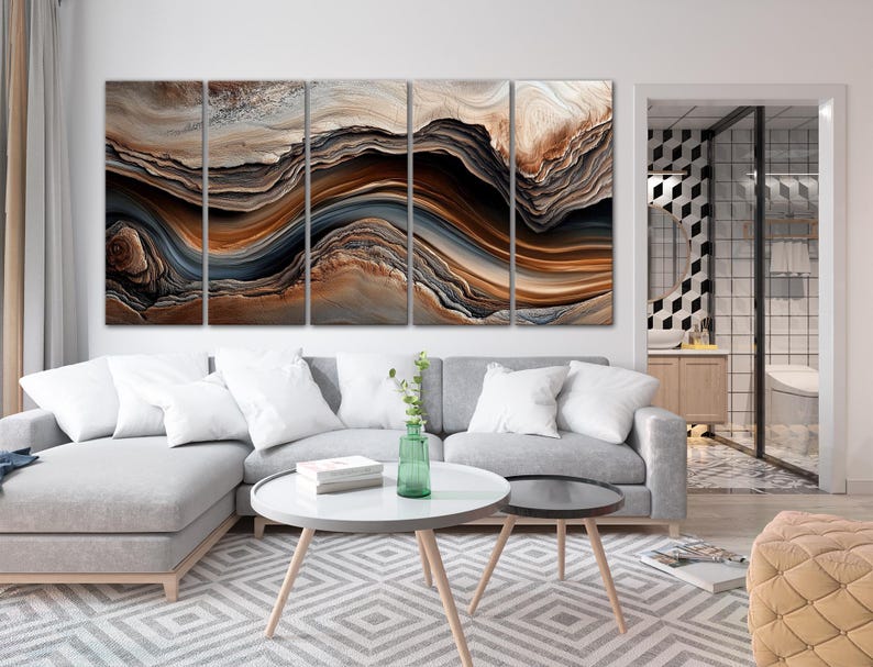 a modern living room with a large abstract painting on the wall, a gray sofa, a round coffee table, and a glass-walled bathroom visible in the background.