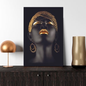 May include: A black and gold abstract portrait of a woman with her eyes closed. She is wearing a gold headpiece and large gold earrings. The background is black.