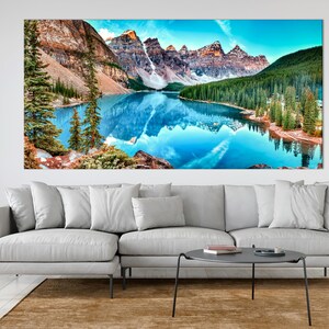 May include: A panoramic view of a mountain lake with snow-capped peaks reflected in the turquoise water. Lush green trees line the shore, creating a serene and picturesque landscape.