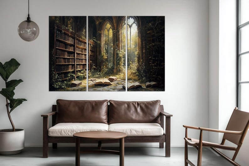 May include: A three-panel wall art set depicting an interior scene of a library with tall wooden bookshelves filled with books, stone floors, open books scattered on the ground, and large arched windows with sunlight streaming into the room.