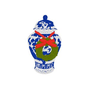 Pode incluir: Um jarro de gengibre de porcelana azul e branco com uma coroa verde e um laço vermelho em volta do pescoço.
