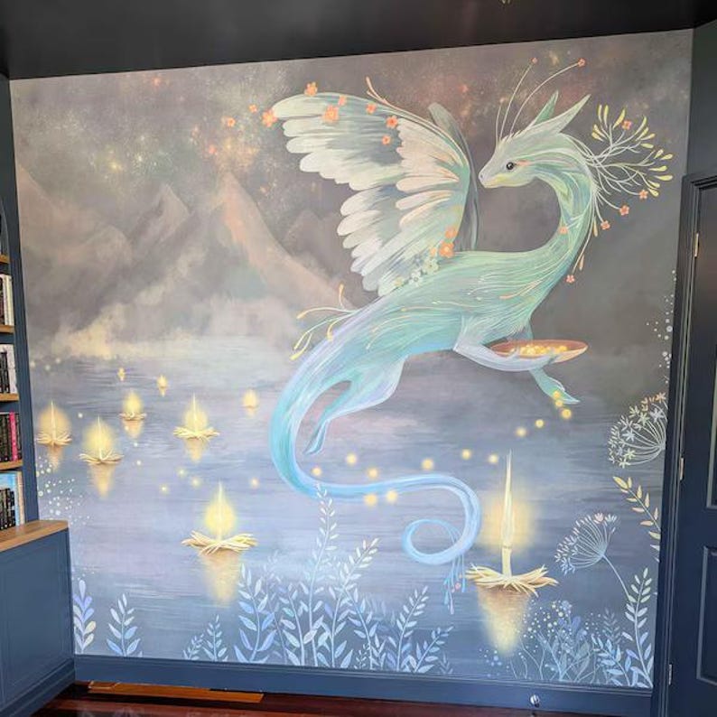 May include: A wall mural featuring a light blue winged dragon hovering over a body of water. The dragon holds a small bowl, surrounded by glowing floating lanterns, misty mountains in the background, and delicate floral accents in soft pastel tones.