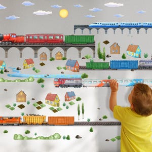 May include: A set of colorful train and house wall decals for kids' rooms. The decals feature a red train with a black engine, a blue train, and several colorful houses. The decals are perfect for creating a fun and whimsical train theme in a child's bedroom.