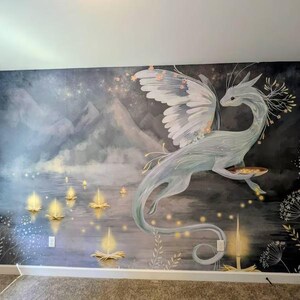 May include: A wall mural featuring a large, pale blue dragon with expansive wings flying over a dark, misty landscape. The scene includes glowing, golden lotus-shaped lights floating on water, set against a backdrop of tall, shadowy mountains.