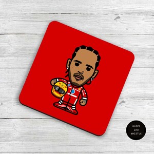 May include: Red square coaster with a cartoon illustration of a race car driver wearing a red racing suit and holding a yellow helmet. The driver has a black beard and brown hair. The text "MOM" is on the helmet.