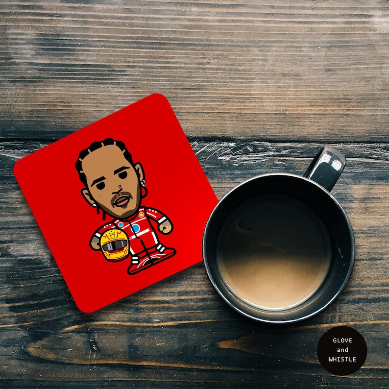 May include: Red square coaster with a cartoon illustration of a race car driver wearing a red racing suit and holding a yellow helmet. The driver has brown skin and short black hair. The coaster has the number "164" on it.