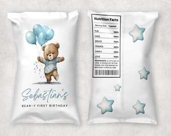 May include: A white favor bag with a blue and white star pattern. The bag features a cartoon bear holding blue balloons and the text "Sebastian's Bear-Y First Birthday". The back of the bag has a nutrition facts label with the text "FUN 100%, CAKE 100%, SMILES 100%, FRIENDS 100%, FAMILY 100%, LOVE 100%".