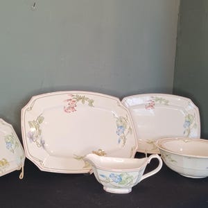 Puede incluir: Un juego de platos de porcelana blanca con diseños florales. El juego incluye una fuente ovalada grande, una fuente ovalada más pequeña, un tazón pequeño y una salsera.