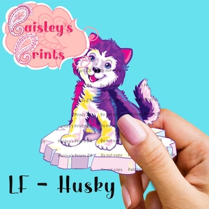 Pode incluir: Um cão husky de desenho animado roxo e branco com olhos azuis sentado em um bloco de gelo rosa e branco. O cão está sorrindo e tem um nariz rosa. O texto "LF - Husky" está abaixo da imagem.