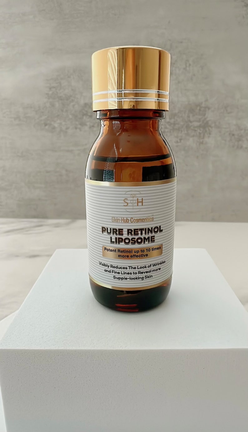 May include: A brown glass bottle with a gold cap, labeled "PURE RETINOL LIPOSOME." The label includes text about reducing wrinkles. The bottle is on a white surface, suggesting a skincare product.