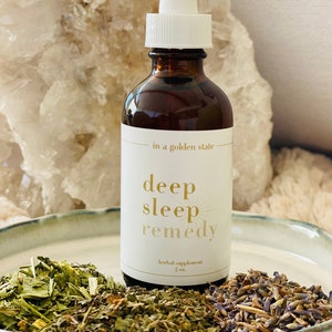 May include: A brown glass bottle with a white dropper top and a white label that reads "in a golden state deep sleep remedy herbal supplement 2 oz."