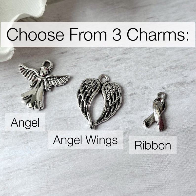 May include: Choose from 3 charms: Angel, Angel Wings, Ribbon. The charms are silver and have a detailed design.