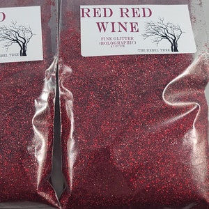 May include: Four clear plastic bags filled with red glitter labeled "Red Red Wine Fine Glitter Holographic" with a small tree logo and the text "The Rebel Tree".