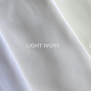 A neatly arranged image showcasing twi sheer fabric swatches in soft, neutral tones. The left side display white and right side display Ivory. The fabrics’ delicate textures and subtle color differences are clearly visible under soft lighting.