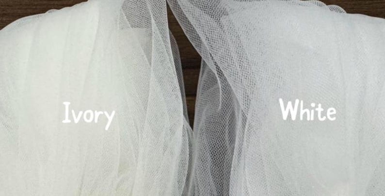 Side-by-side close-up of bridal soft tulle swatches labeled "Ivory" and "White" showing color and texture differences; ivory appears warm and creamy while white is brighter and crisp. Perfect for brides choosing between white and ivory wedding veils with blusher; highlights sheer, lightweight tulle weave and tonal match against gowns. Suitable for Etsy listings, fabric comparison, and veil color selection.