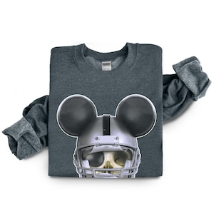 Puede incluir: Una sudadera gris oscuro jaspeada con un gr&aacute;fico de una calavera con un casco de f&uacute;tbol americano y orejas de Mickey Mouse.