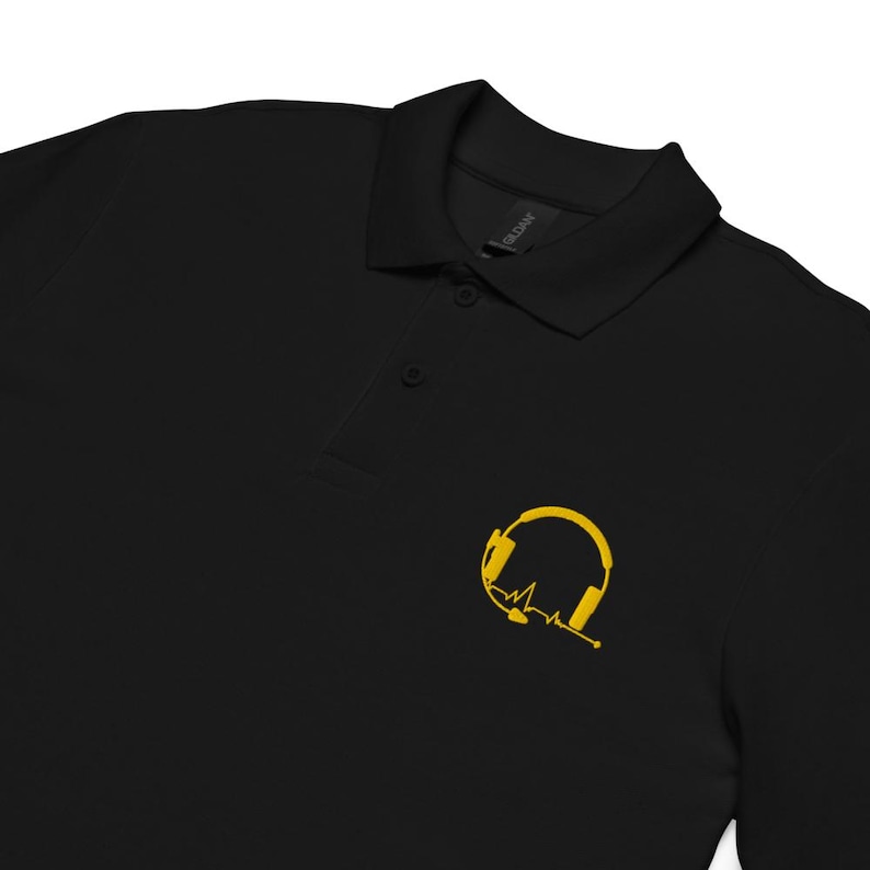 May include: Black polo shirt with a yellow embroidered design of headphones with a heartbeat line.